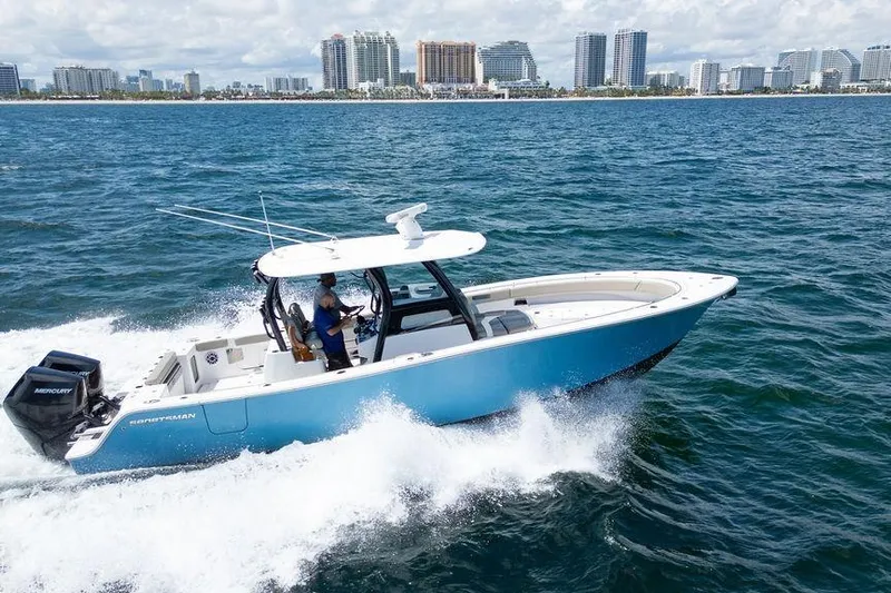 Change Clothes Yacht Photos Pics 2023 Sportsman Open 322 Center Console boat cruising on ocean near city skyline.