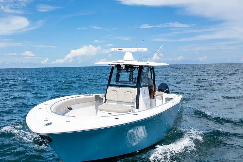 Change Clothes Yacht Photos Pics 2023 Sportsman Open 322 Center Console boat cruising on open ocean under blue sky.