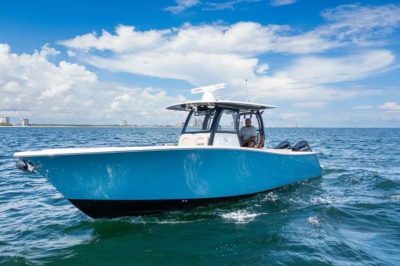 Change Clothes Yacht Photos Pics 2023 Sportsman Open 322 Center Console boat cruising on open water under a clear sky.