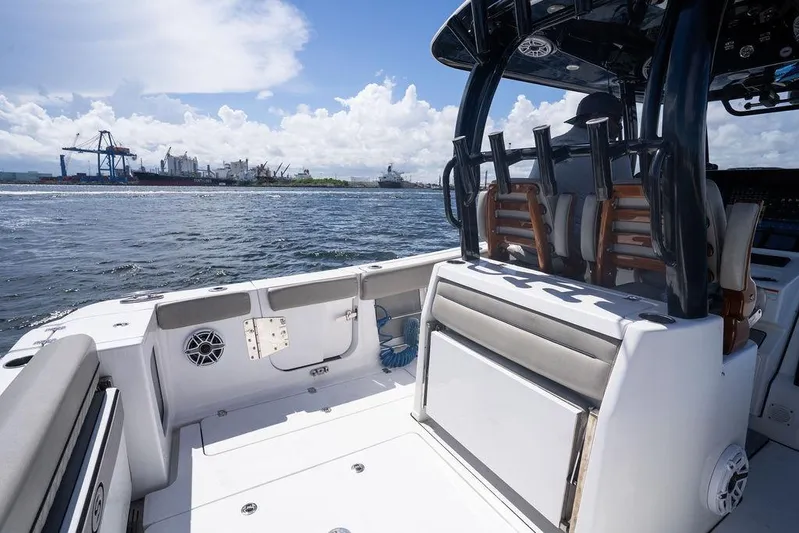 Change Clothes Yacht Photos Pics 2023 Sportsman Open 322 Center Console boat on water, with industrial port background.