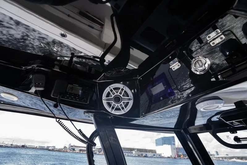 Change Clothes Yacht Photos Pics 2023 Sportsman Open 322 Center Console interior with speaker and control panel, overlooking waterfront.