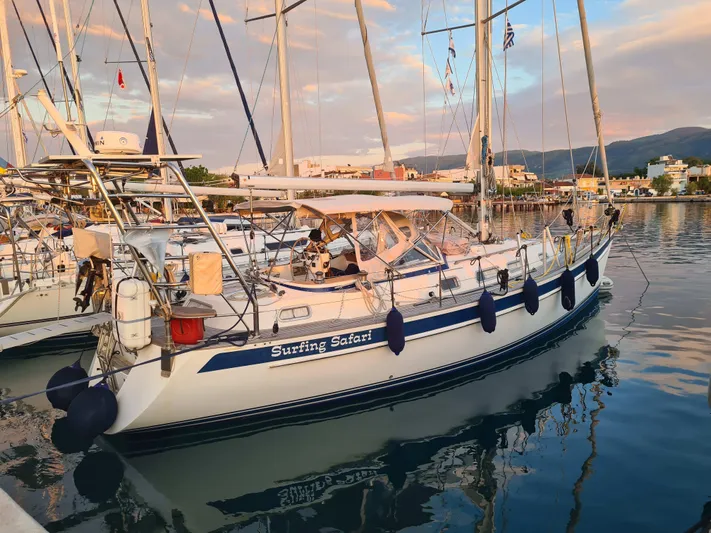 Surfing Safari Yacht Photos Pics 2010 Hallberg-Rassy 40 sailboat docked at marina, reflecting on calm water.