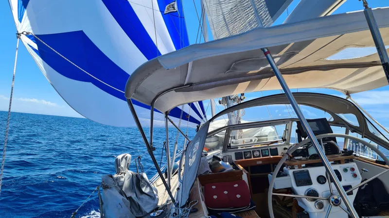 Surfing Safari Yacht Photos Pics Sailing on a 2010 Hallberg-Rassy 40 yacht with blue and white sails on open sea.