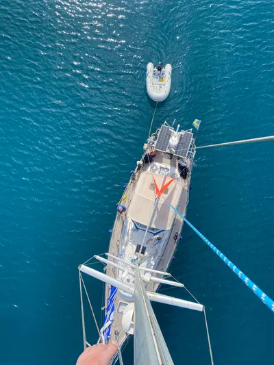 Surfing Safari Yacht Photos Pics Aerial view of 2010 Hallberg-Rassy 40 sailboat with dinghy on blue water.