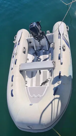 Surfing Safari Yacht Photos Pics Inflatable boat with motor, floating on water, viewed from above.