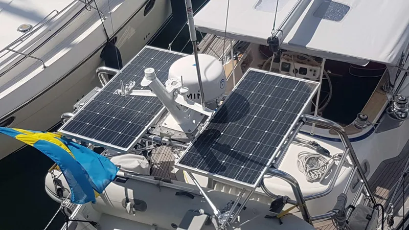 Surfing Safari Yacht Photos Pics Sailboat with solar panels, Hallberg-Rassy 40, 2010 model, docked with a flag.
