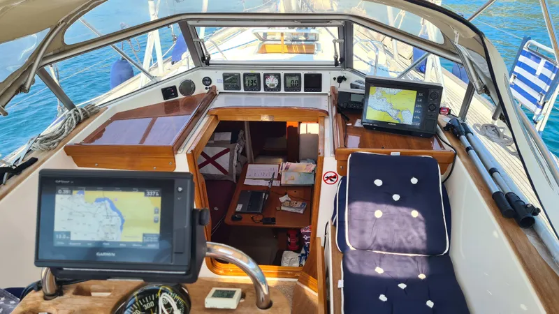 Surfing Safari Yacht Photos Pics Interior view of a 2010 Hallberg-Rassy 40 sailboat cockpit with navigation equipment.