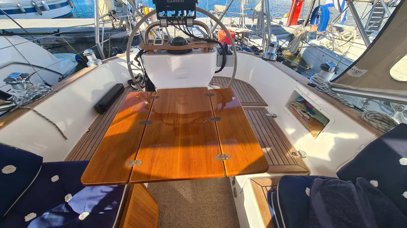 Surfing Safari Yacht Photos Pics Cockpit of 2010 Hallberg-Rassy 40 sailboat with wooden table and seating.