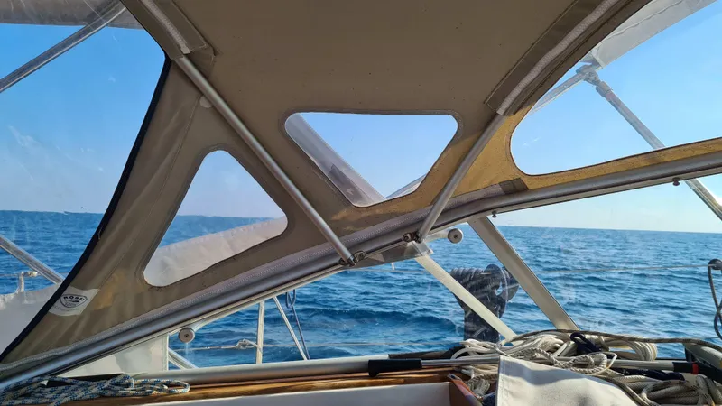 Surfing Safari Yacht Photos Pics View from a 2010 Hallberg-Rassy 40 sailboat cockpit, overlooking the ocean under a clear sky.