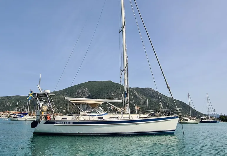 Surfing Safari Yacht Photos Pics 2010 Hallberg-Rassy 40 sailboat anchored in scenic bay with mountains in background.