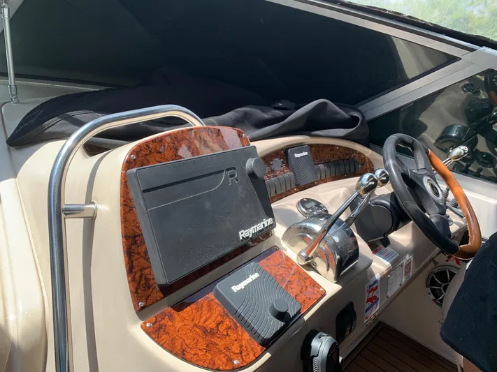 Tbd Yacht Photos Pics Helm of 2002 Sea Ray 340 Sundancer with Raymarine navigation system and wood accents.