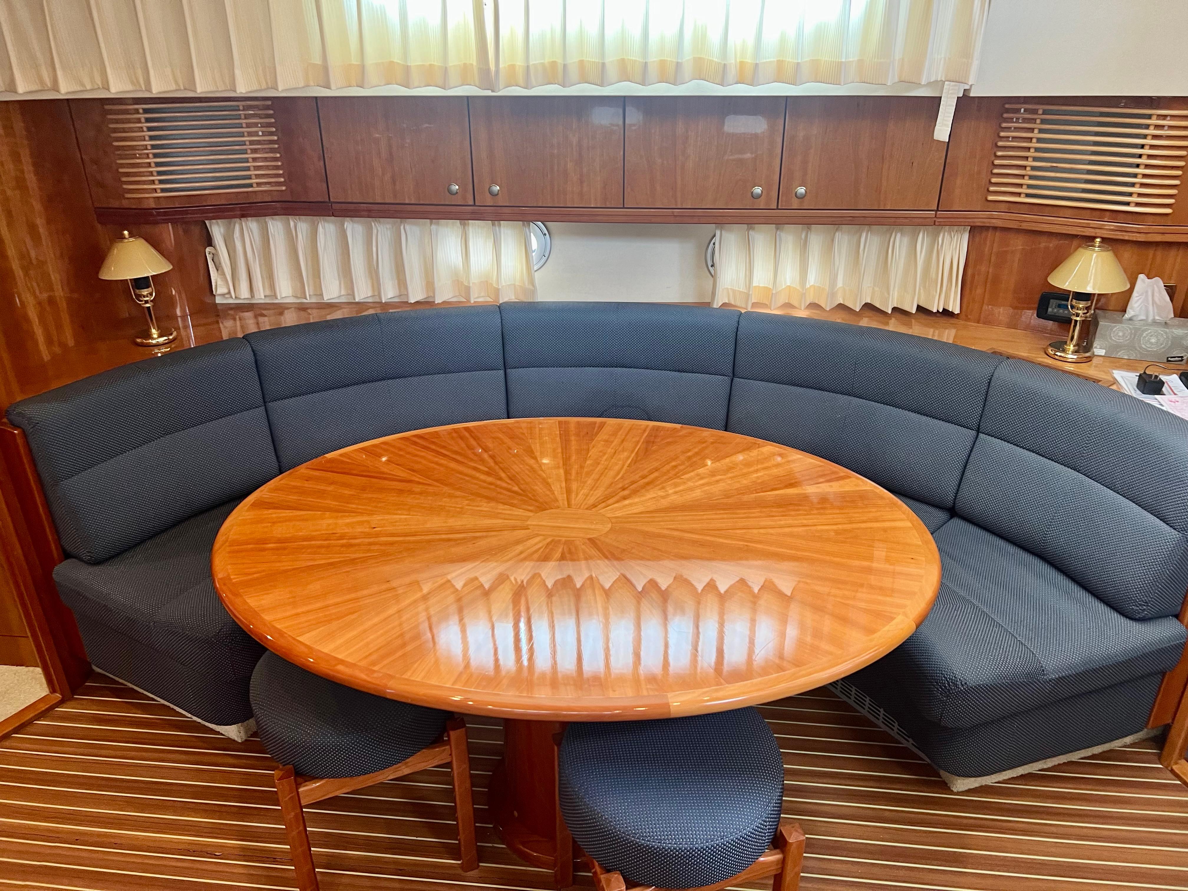 Luxurious Elling E4 2008 yacht interior with elegant wood table and curved seating.