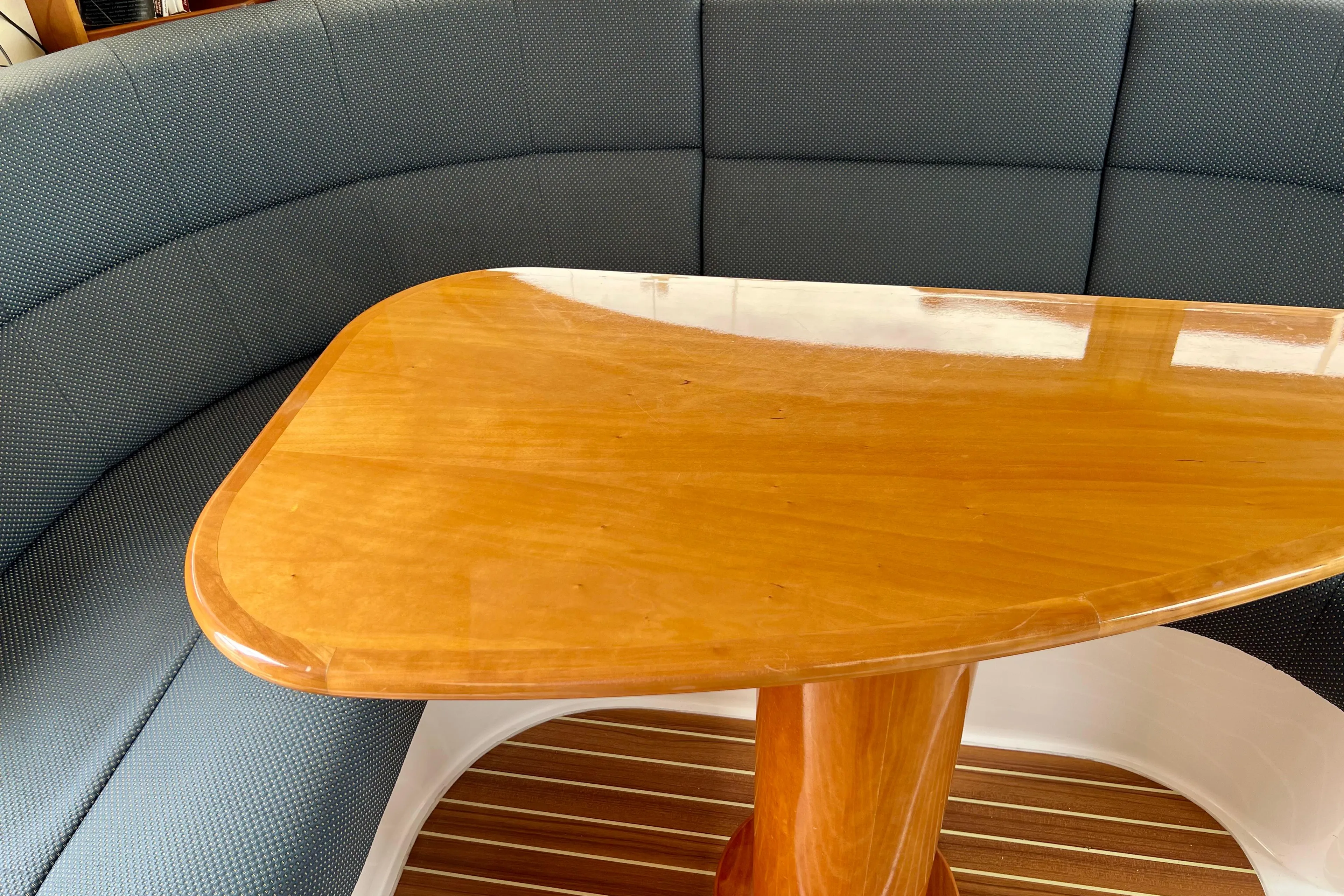 Luxurious interior of 2008 Elling E4 yacht with wooden table and cushioned seating.