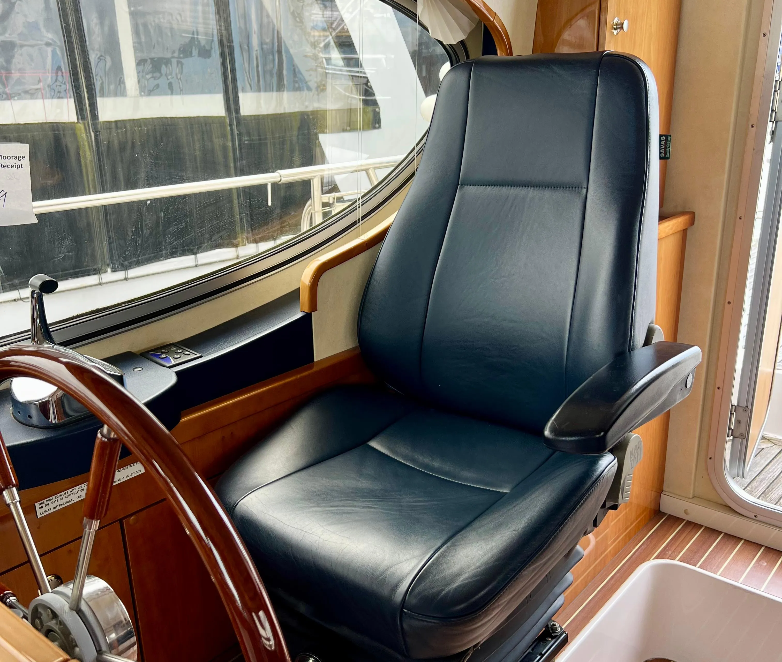 Captain's chair in 2008 Elling E4 yacht cockpit, featuring leather upholstery and wooden accents.