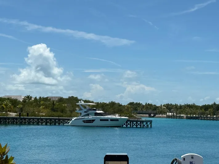 Rio Yacht Photos Pics 2017 Cruisers Yachts 60 Fly docked in a tropical marina under a clear blue sky.