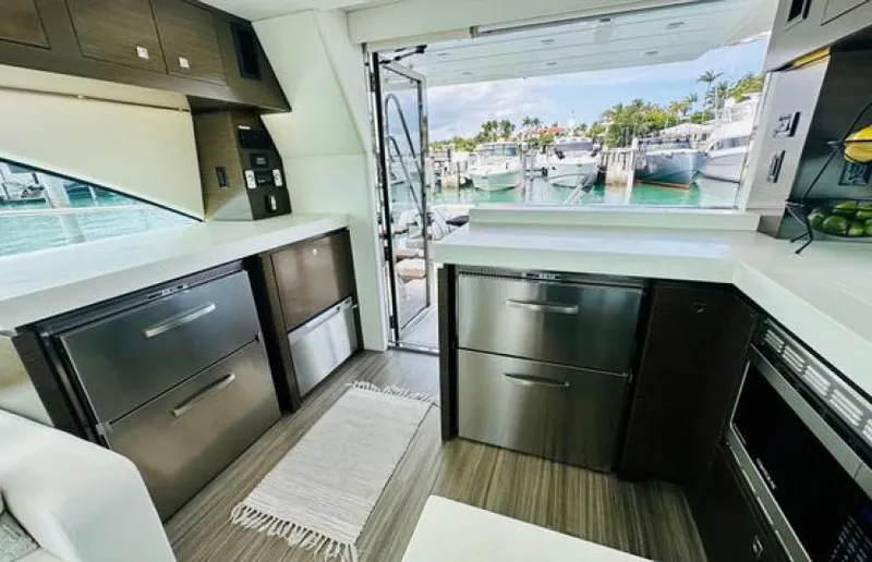 Rio Yacht Photos Pics Luxurious 2017 Cruisers Yachts 60 Fly kitchen with marina view, featuring modern appliances.
