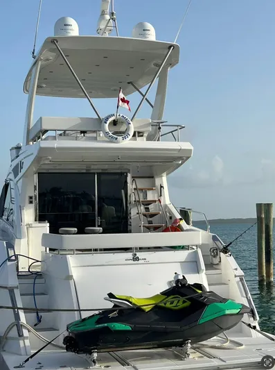 Rio Yacht Photos Pics 2017 Cruisers Yachts 60 Fly with jet ski on deck, docked by the water.