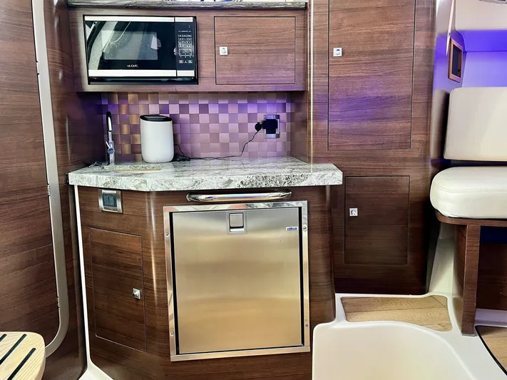 " Margin Call " Yacht Photos Pics 2018 Boston Whaler 345 Conquest interior with kitchenette, featuring microwave, sink, and stainless steel fridge.