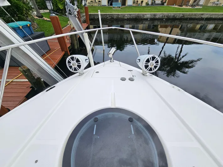  Yacht Photos Pics 2022 Regal 33 XO boat bow with speakers, docked by a canal.