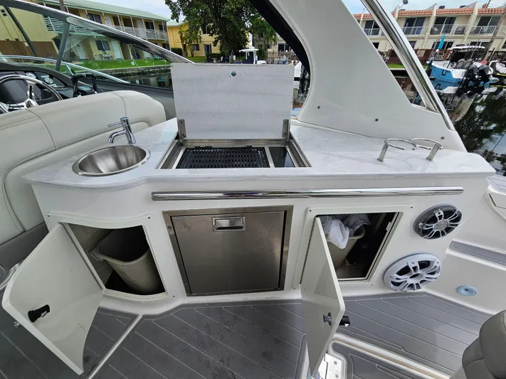  Yacht Photos Pics 2022 Regal 33 XO yacht kitchenette with sink, grill, and storage compartments.