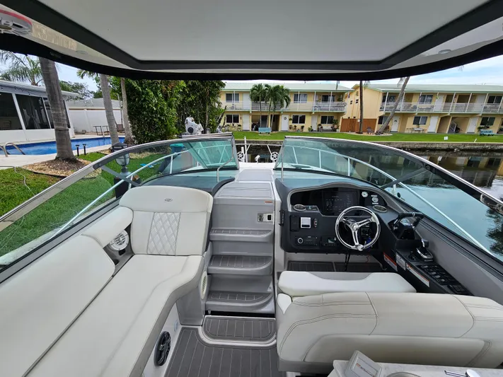  Yacht Photos Pics 2022 Regal 33 XO boat interior with modern helm and seating, docked near waterfront homes.