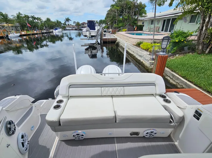  Yacht Photos Pics 2022 Regal 33 XO boat with luxurious seating by a serene waterfront.