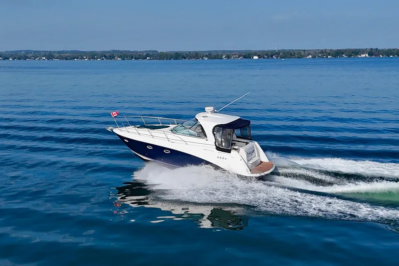 Escape Yacht Photos Pics 2009 Rinker 360 Express Cruiser speeding on a calm blue lake.
