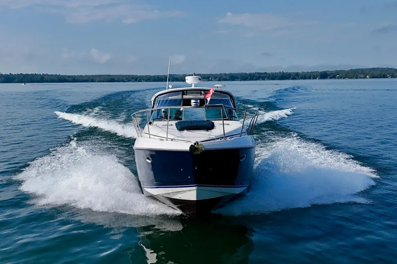 Escape Yacht Photos Pics 2009 Rinker 360 Express Cruiser speeding on a clear blue lake.