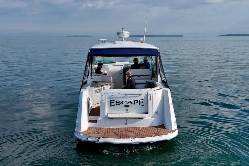 Escape Yacht Photos Pics 2009 Rinker 360 Express Cruiser on calm waters, rear view with passengers onboard.