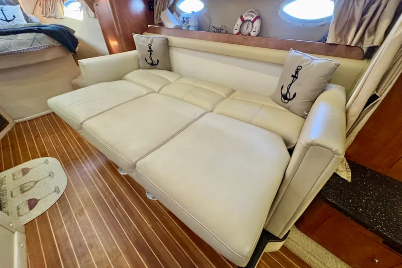 Escape Yacht Photos Pics 2009 Rinker 360 Express Cruiser interior with beige leather sofa and nautical-themed pillows.