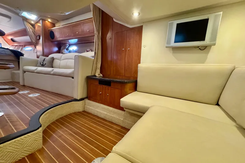 Escape Yacht Photos Pics 2009 Rinker 360 Express Cruiser interior with beige seating, wood accents, and mounted TV.