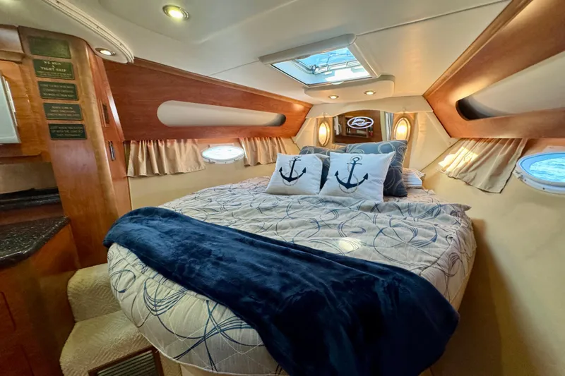 Escape Yacht Photos Pics Luxurious cabin interior of 2009 Rinker 360 Express Cruiser with nautical-themed bedding.
