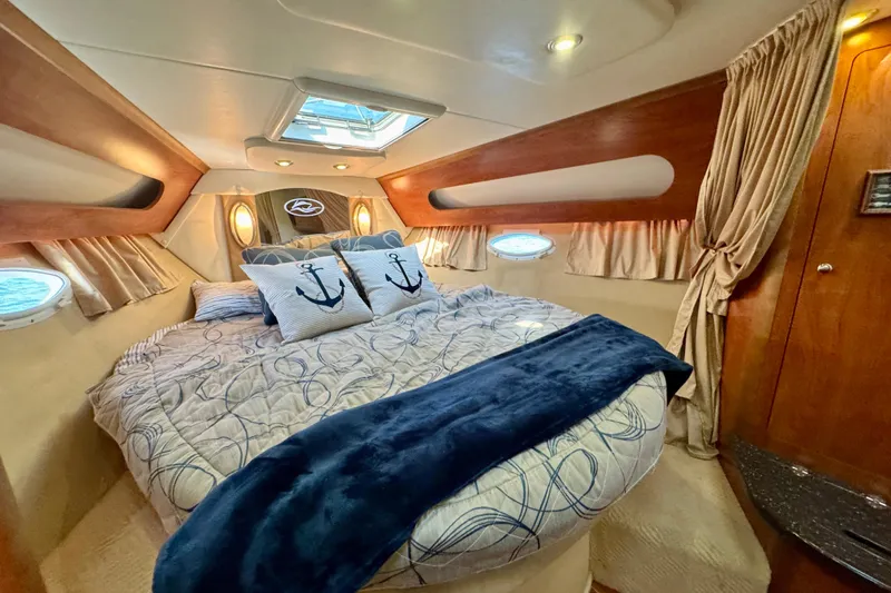 Escape Yacht Photos Pics Luxurious cabin interior of 2009 Rinker 360 Express Cruiser with nautical-themed bedding.