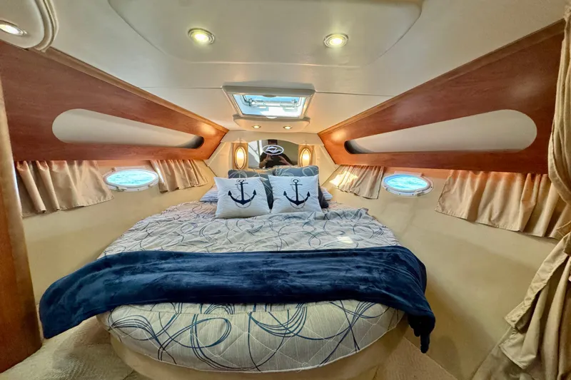 Escape Yacht Photos Pics Luxurious 2009 Rinker 360 Express Cruiser cabin with cozy bedding and nautical decor.