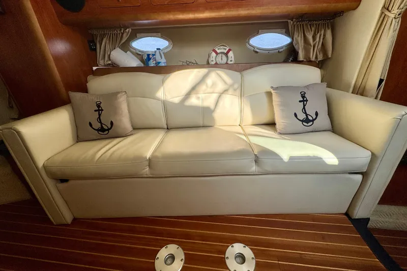 Escape Yacht Photos Pics 2009 Rinker 360 Express Cruiser interior with cream sofa and anchor-themed pillows.