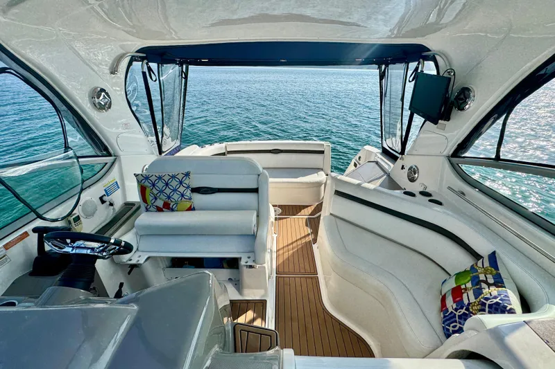 Escape Yacht Photos Pics 2009 Rinker 360 Express Cruiser interior with ocean view, featuring white seating and colorful cushions.