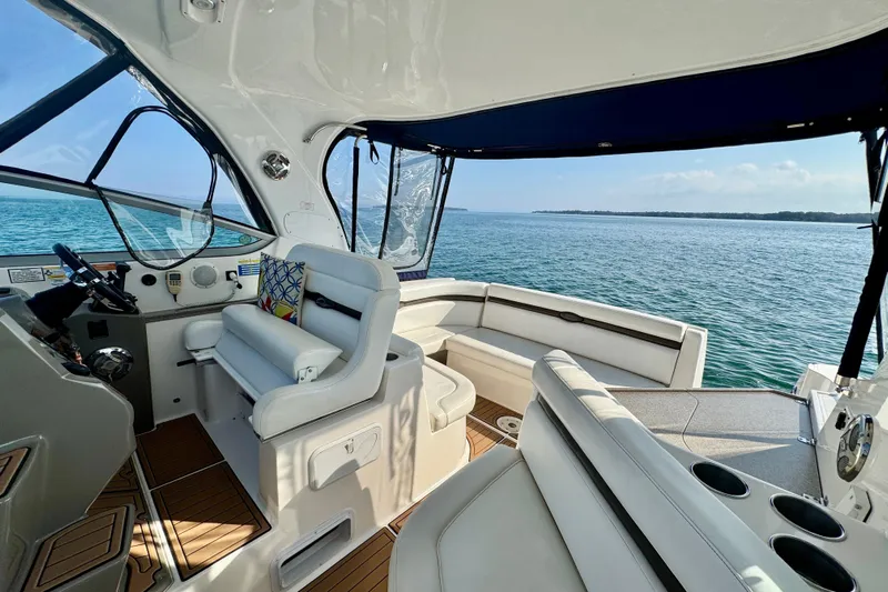 Escape Yacht Photos Pics 2009 Rinker 360 Express Cruiser interior with ocean view, featuring white seating and wooden flooring.