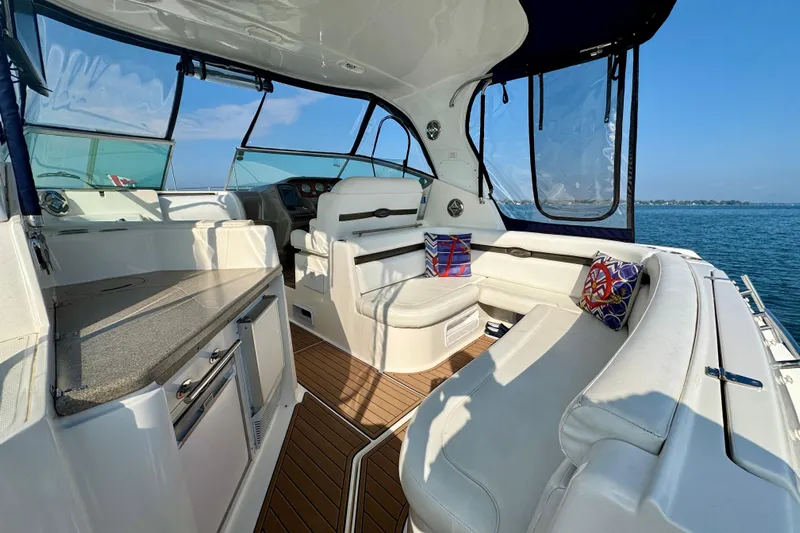 Escape Yacht Photos Pics 2009 Rinker 360 Express Cruiser interior with white seating, wooden flooring, and scenic ocean view.