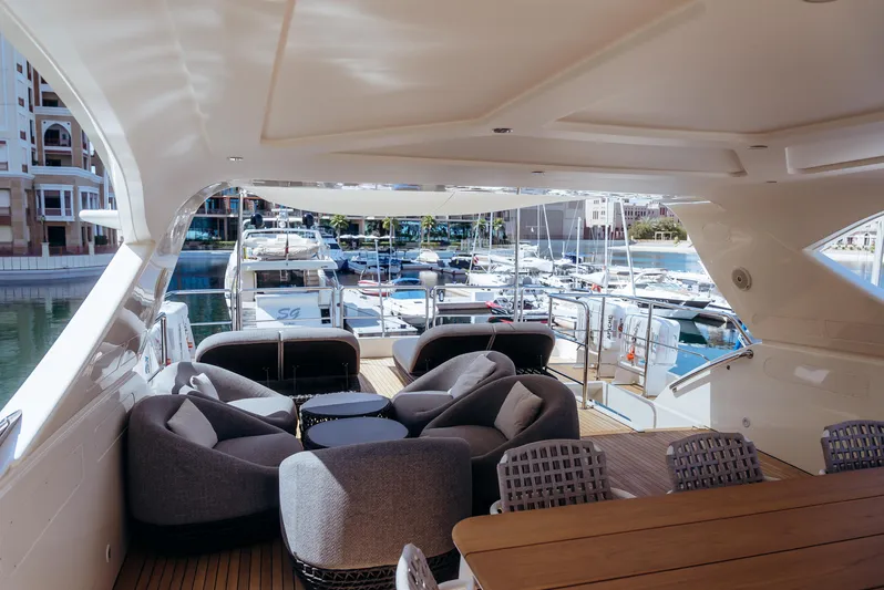 Apache Yacht Photos Pics Luxurious 2004 Falcon 86 yacht with elegant seating, docked in a scenic marina.