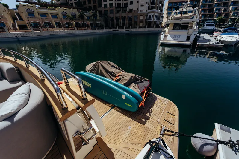 Apache Yacht Photos Pics Luxurious Falcon 86 yacht docked, featuring a paddleboard and serene marina view.