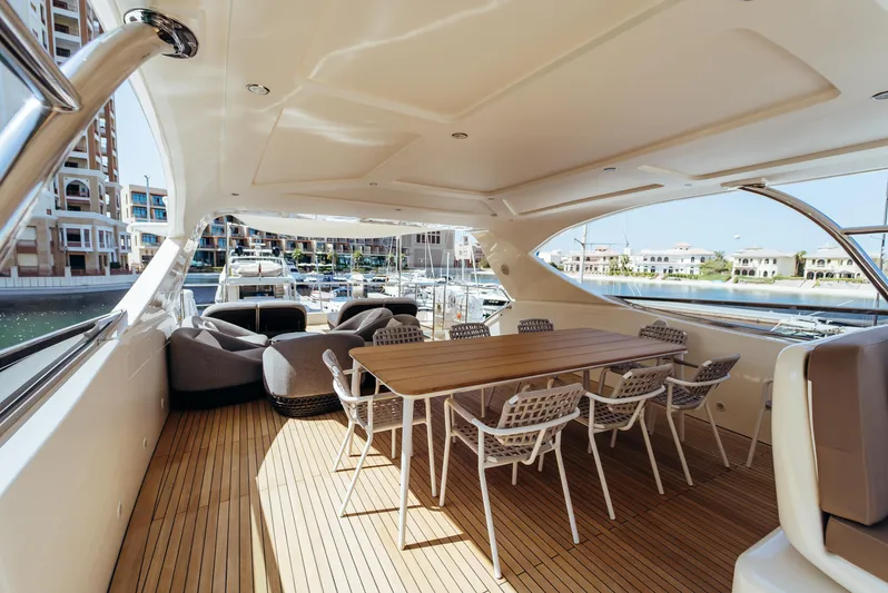 Apache Yacht Photos Pics Luxurious Falcon 86 yacht deck with dining area, modern seating, and marina view, 2004 model.