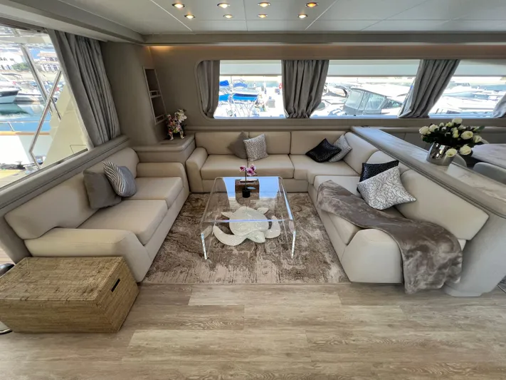 Apache Yacht Photos Pics Luxurious yacht interior with beige sofas, glass table, and marina view. Falcon 86, 2004 model.
