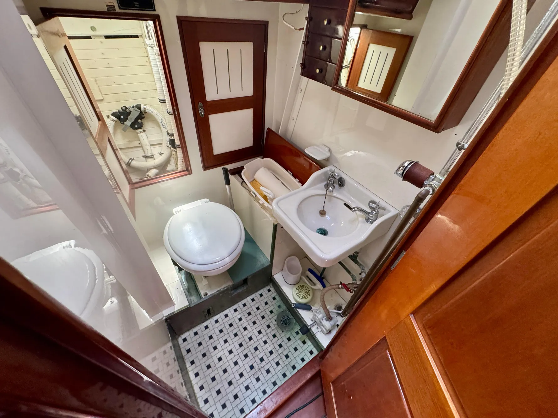 Bathroom interior of a 1956 Aage Nielsen 50' Yawl, featuring sink and toilet.
