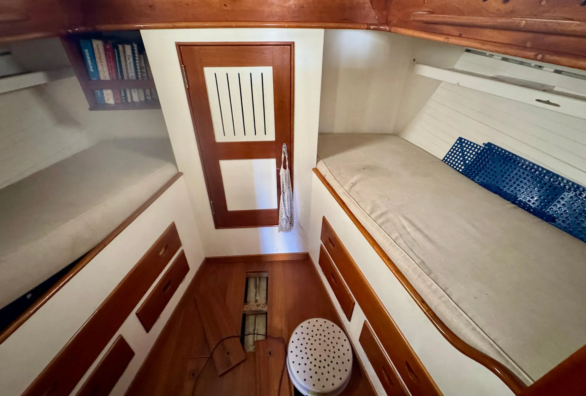 Cozy cabin interior of 1956 Aage Nielsen 50' Yawl with wooden finishes and bunks.