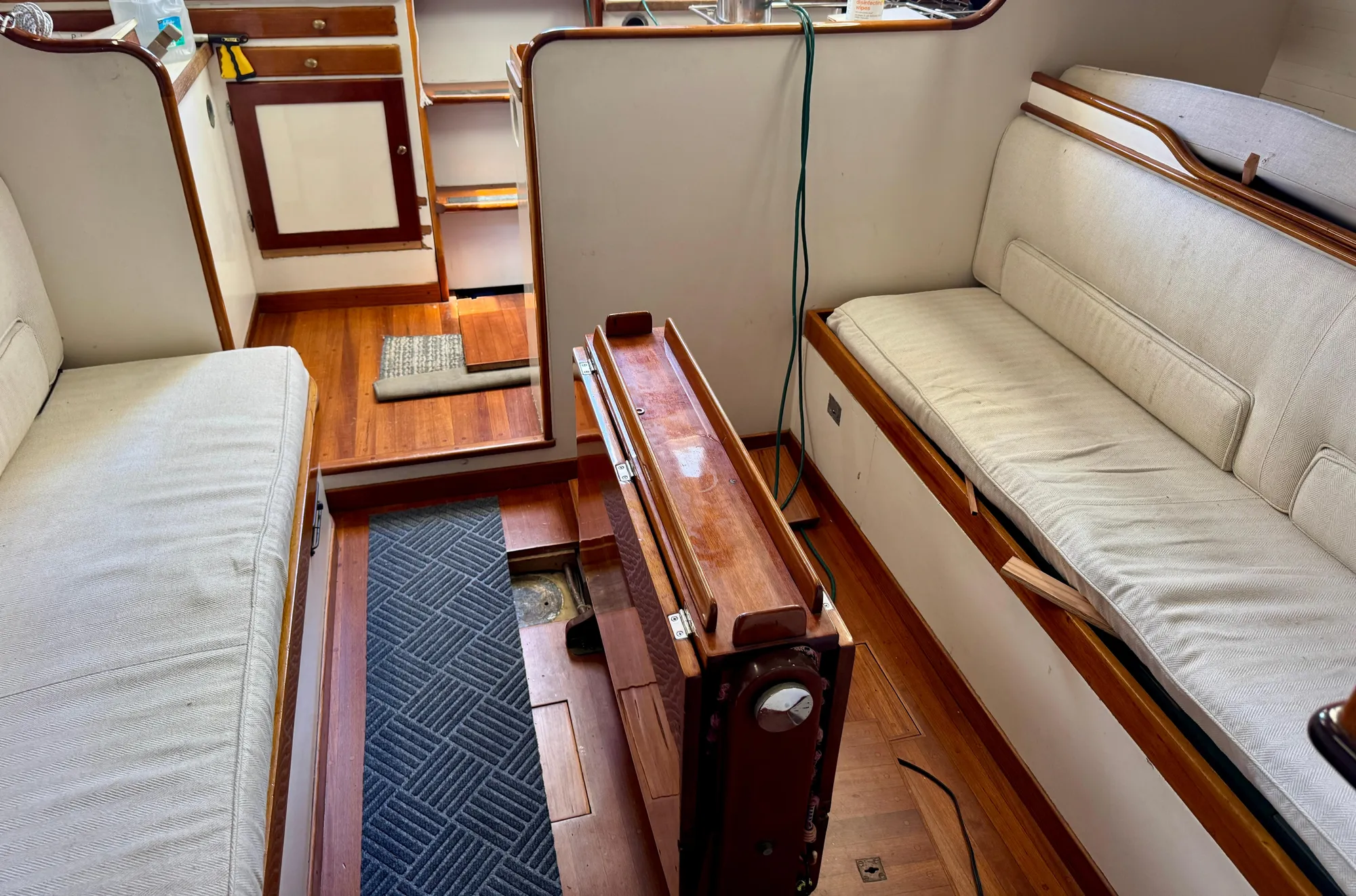 Interior of a 1956 Aage Nielsen 50' Yawl, featuring wooden flooring and cushioned seating.