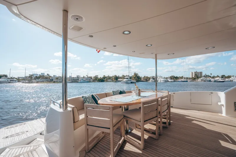 Lady Kristina Yacht Photos Pics Luxurious 2004 Lazzara LY106 yacht deck with dining area overlooking serene waterfront.