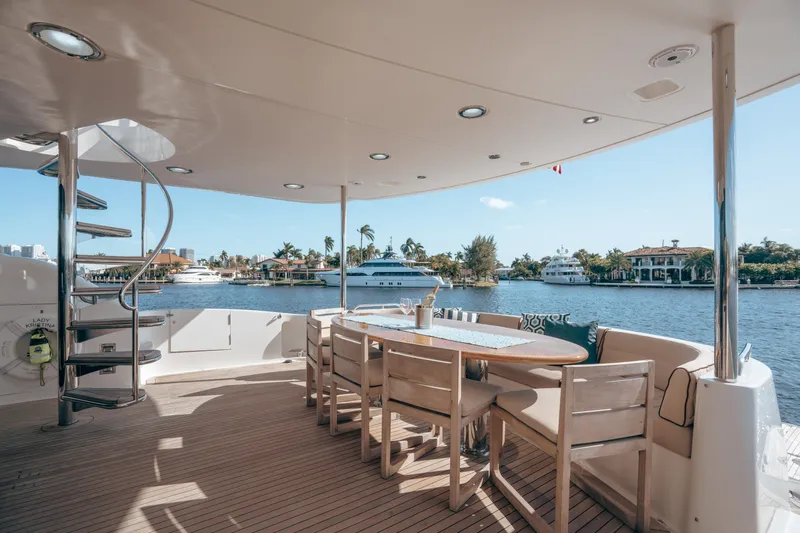Lady Kristina Yacht Photos Pics Luxurious 2004 Lazzara LY106 yacht deck with dining area overlooking serene waterfront.
