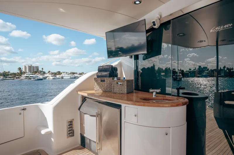 Lady Kristina Yacht Photos Pics Luxurious 2004 Lazzara LY106 yacht deck with outdoor kitchenette and scenic waterfront view.