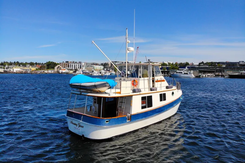 Amazing Grace Yacht Photos Pics 1983 Kadey-Krogen Manatee 36 boat on water, blue sky, marina background.