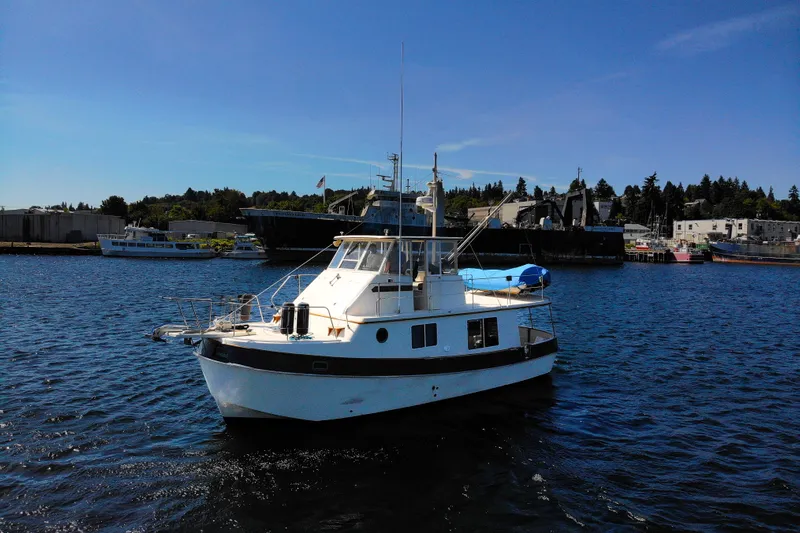 Amazing Grace Yacht Photos Pics 1983 Kadey-Krogen Manatee 36 boat on calm water, with industrial background.